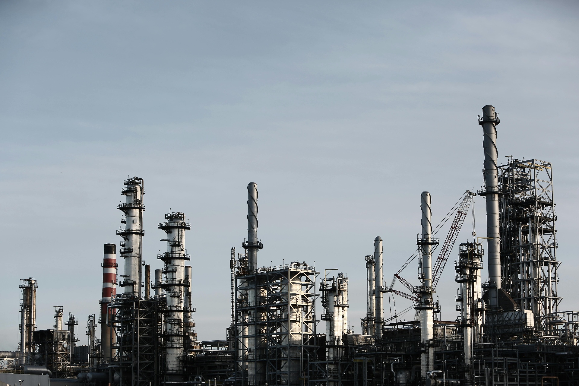 Oil and gas refinery with stacks at dusk
